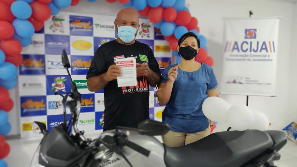 Ganhadora Viviane Medeiros ao lado do companheiro mostra chave da moto 0km